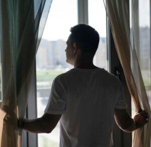 portrait of man with curtains and shadows from window