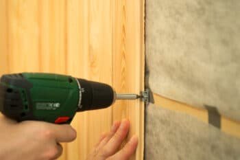 A guy screws on the wall