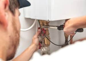 a man installing a heater system in the house
