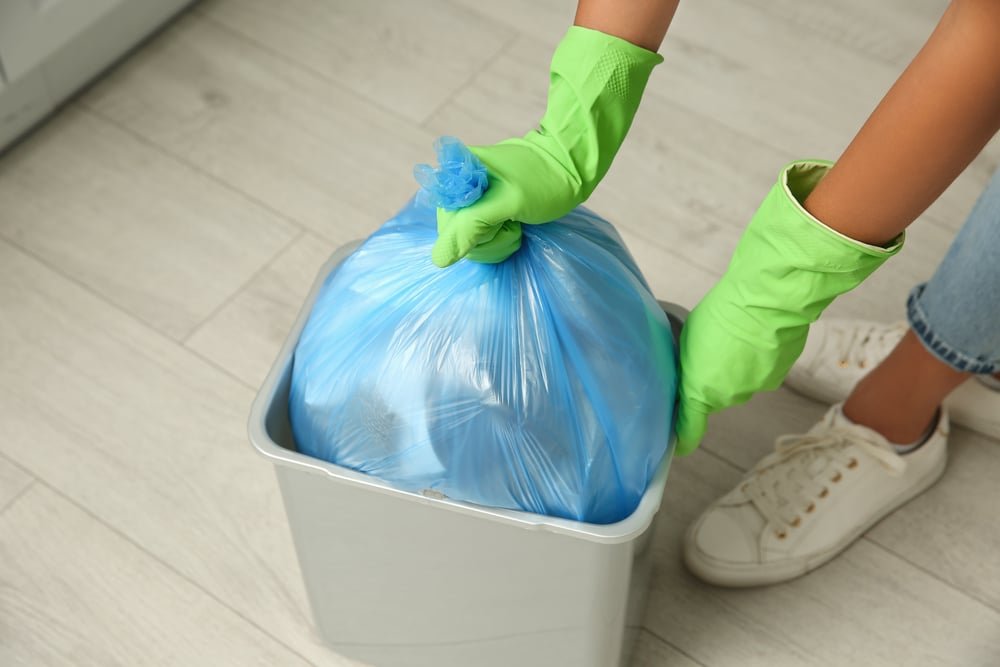 a pair of hands taking out trash