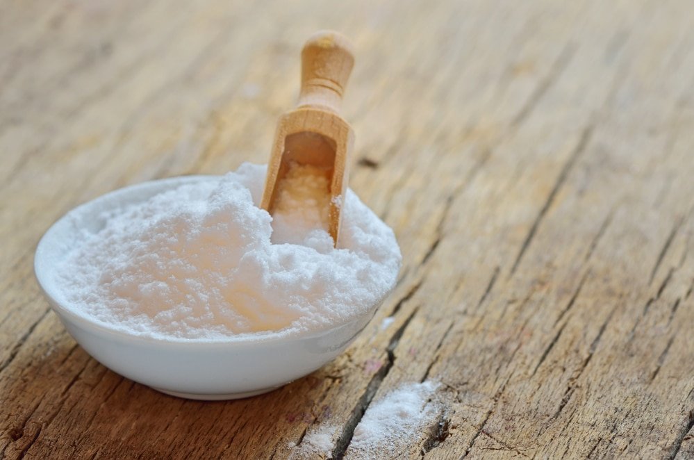 a small bowl of baking soda on wooden table