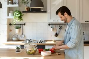 a smiling man preparing a meal