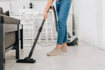 a woman is tidying up the living room area