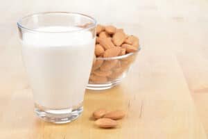 almonds and almond milk on wooden table