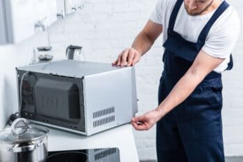 handyman checking kitchen appliance