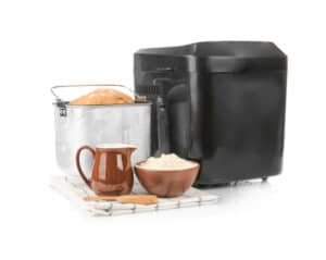Bread machine fresh loaf and ingredients for cooking on white background