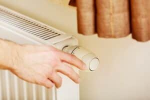 man adjusting heater temperature