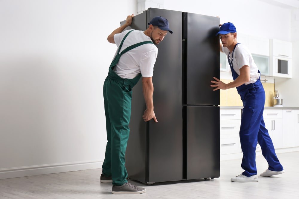 men placing  an appliance in the kitchen