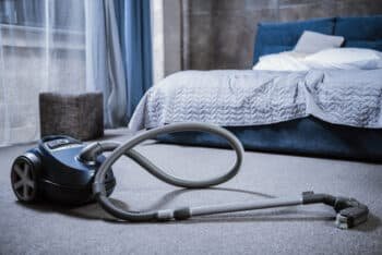 tidying the bedroom floor using an electrical tool