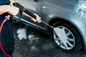 woman cleaning wheels of car