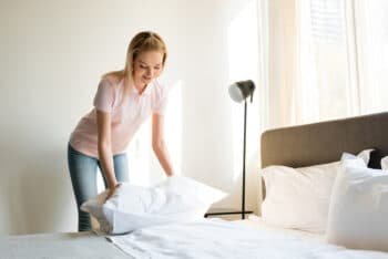 woman fluffing beddings