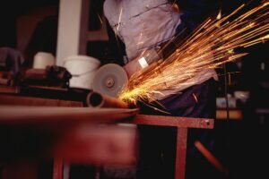 worker sawing metal pipes