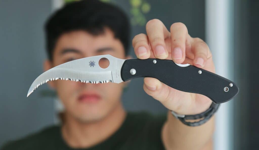 the man holding chef knives has holes
