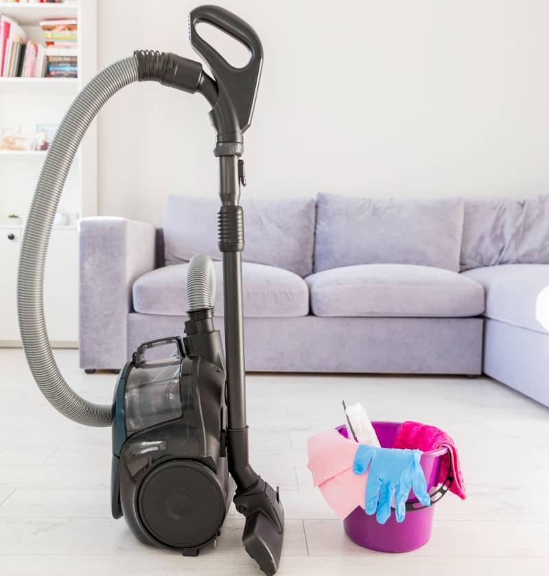 a bagless vacuum cleaner and cleaning tools on the floor