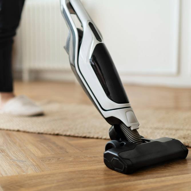 a housewife vacuuming a parquet floor
