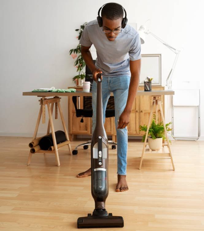 a man cleaning the floor using an upright vacuum cleaner