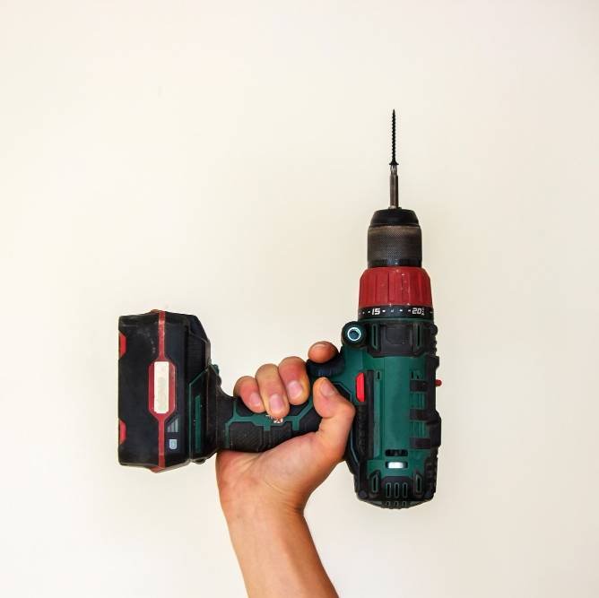 a man holding a cordless drill