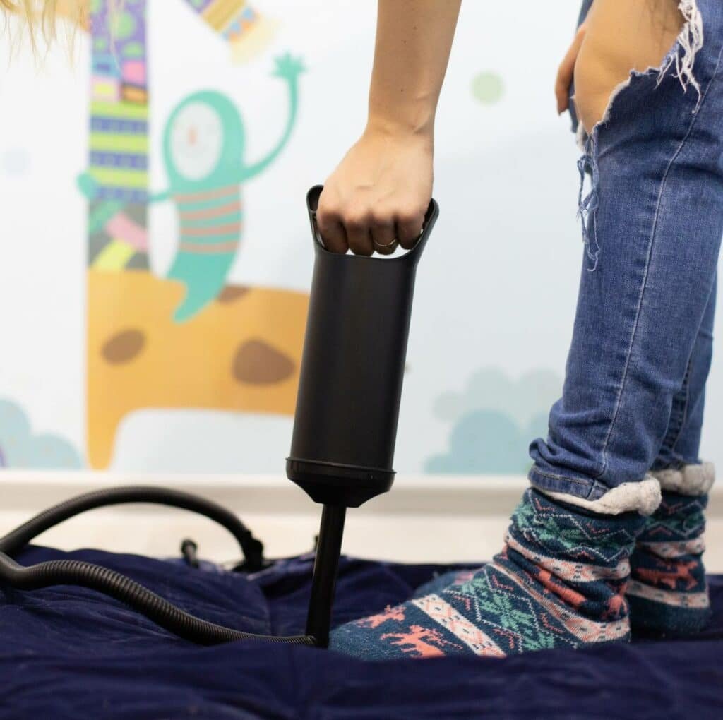 a man pumping an inflatable mattress