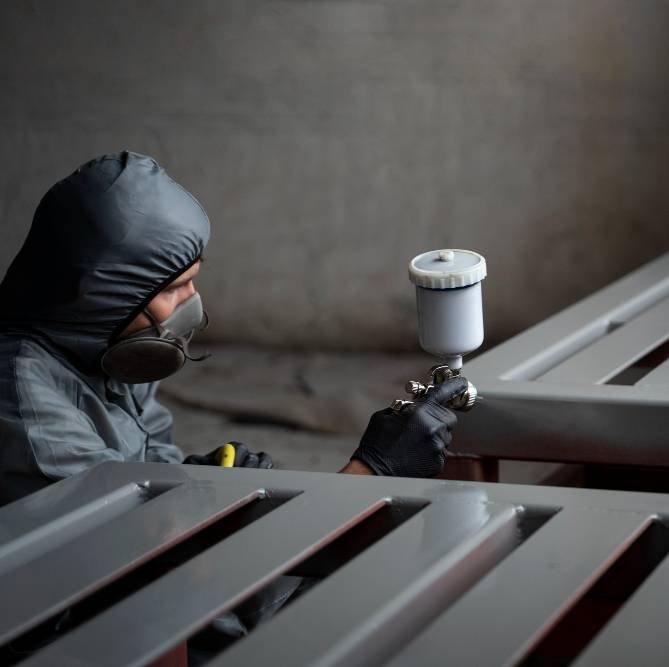 a man spraying powder paint from a gun