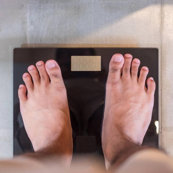 a man stand on the digital weight scale