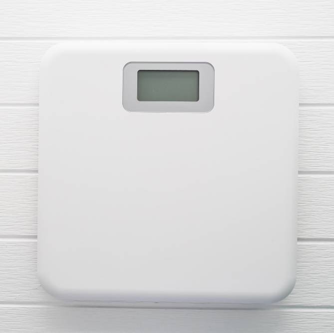 a white digital weight scale on the floor