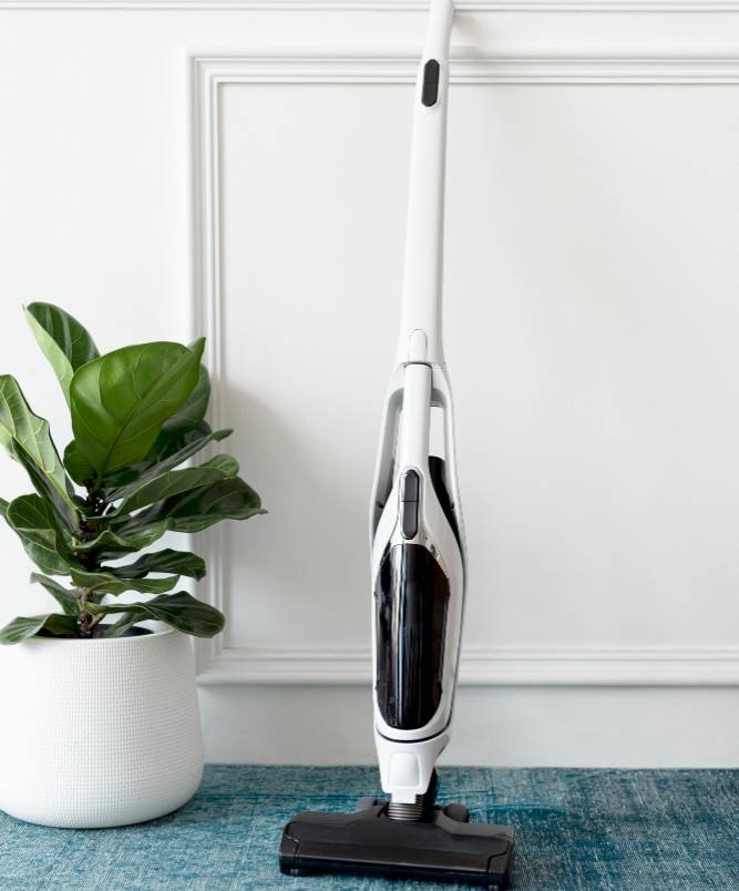 a white handheld vacuum cleaner against the wall
