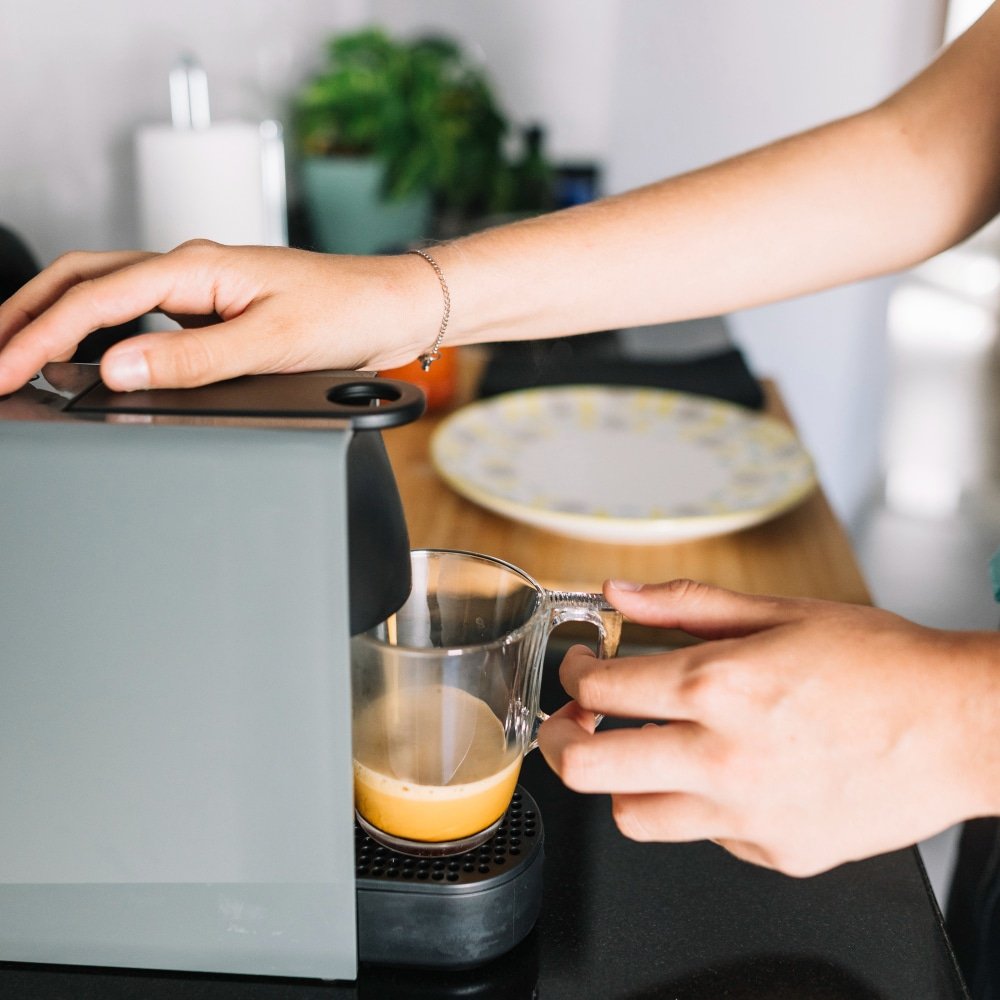 a woman taking coffee from a coffee machine
