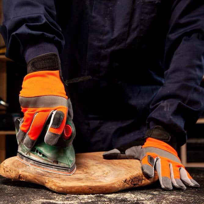 a worker with protective gloves using a multi tool