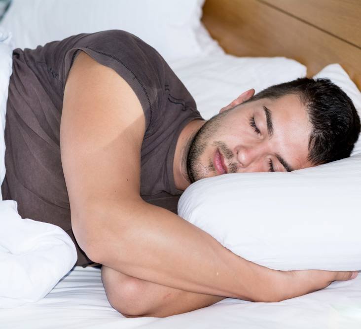 a young man sleeping in his bed