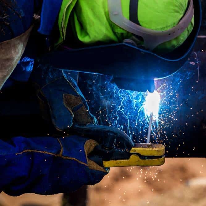 an industrial worker welding a metal pipe