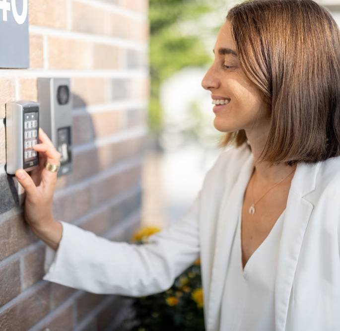 woman entering code on a keyboard to access a door