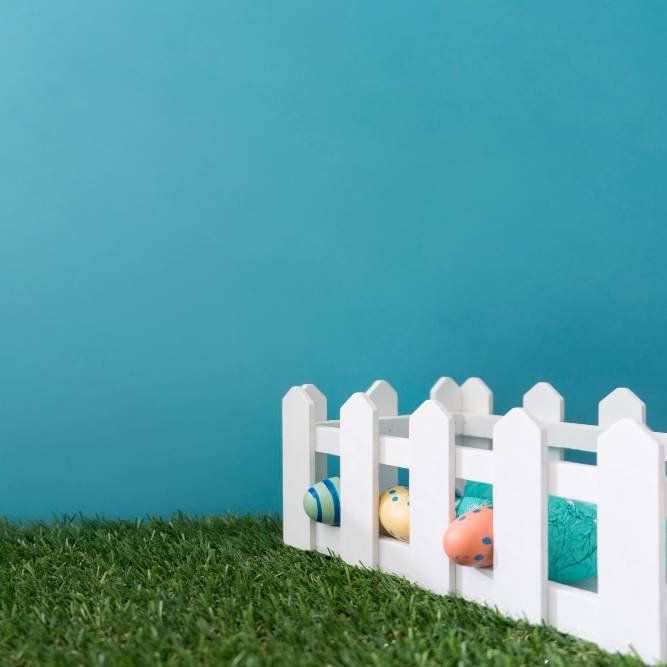 wooden fence with easter eggs on the fake grass